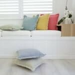 Brightly coloured denim cushions adding texture and colour to a white day bed