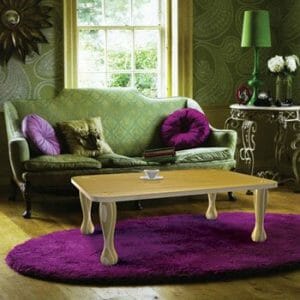 Purple scatter cushions laid out on a green sofa
