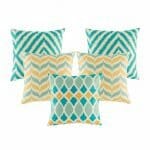 Five cushion in gold and teal colours with diamond and chevron designs.