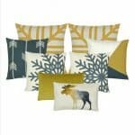 two patterned cushion in gold, one rectangular cushion with moose print, 2 white and blue snowflake cushion, one blue cushion with arrow print and one cushion with linear lines.