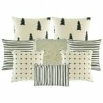 two cushion cover with black and white stripes, two black and white with small cross design, one plain white fur, two pine tree printed cushion, and one rectangular cushion cover
