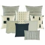 2 cushion with black and white stripes, 1 black and white with small cross design one plain white fur, one pine tree printed cushion, one plain white cushion, one plain dark grey cushion, one black and white with big cross cushion, and one rectangular cushion