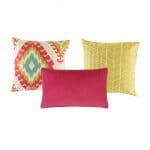 Two patterned cushion in yellow and fuchsia colours and one plain rectangular cushion in fuchsia.
