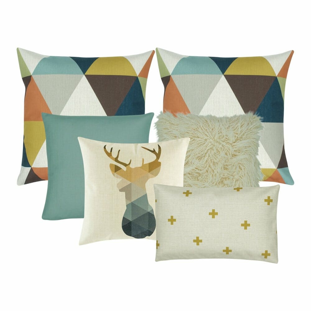 2 square cushion with patterns, 1 teal cushion, 1 white fur cushion, a moose printed cushion and one rectangle cushion with cross design