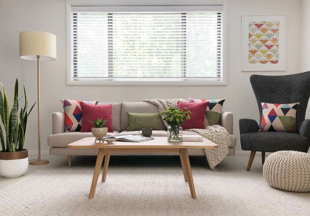 A contemporary style sofa with different patterned cushions in pink,red and purple