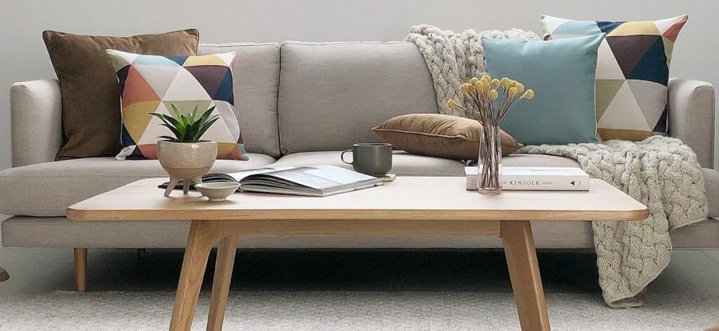 A colourful arrangement of cushions on a grey sofa.