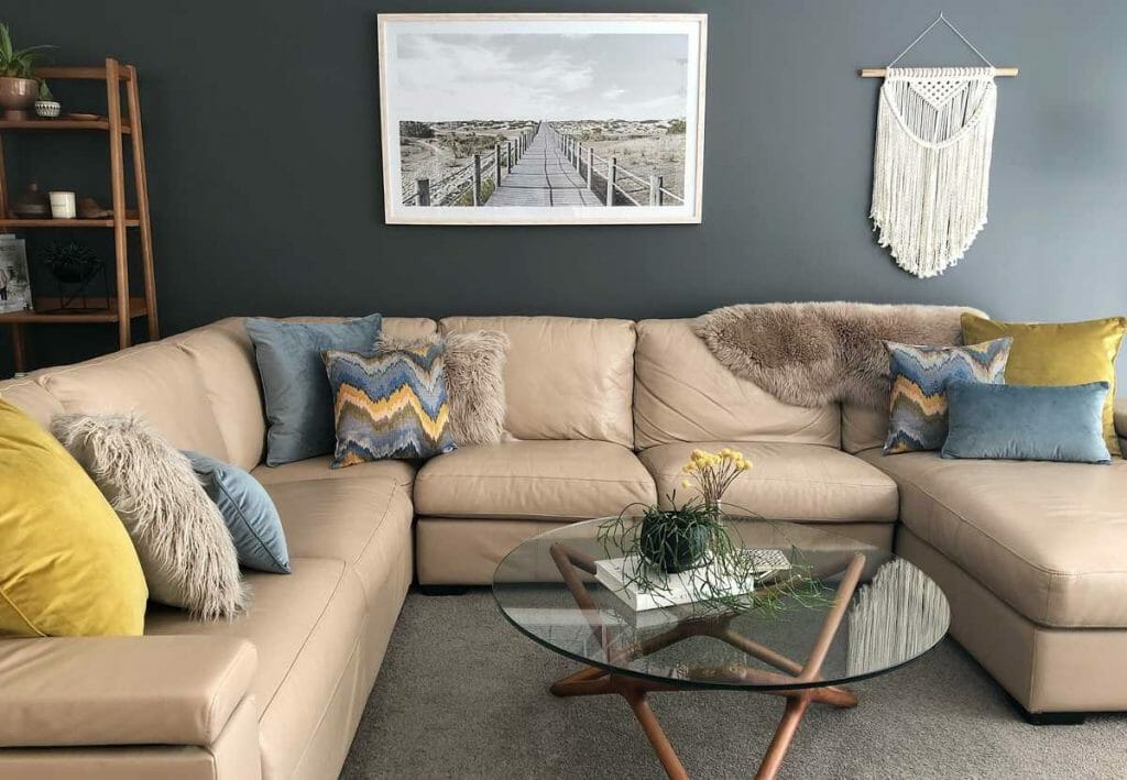 A lounge sofa with velvet decorative cushions in light blue and mustard.