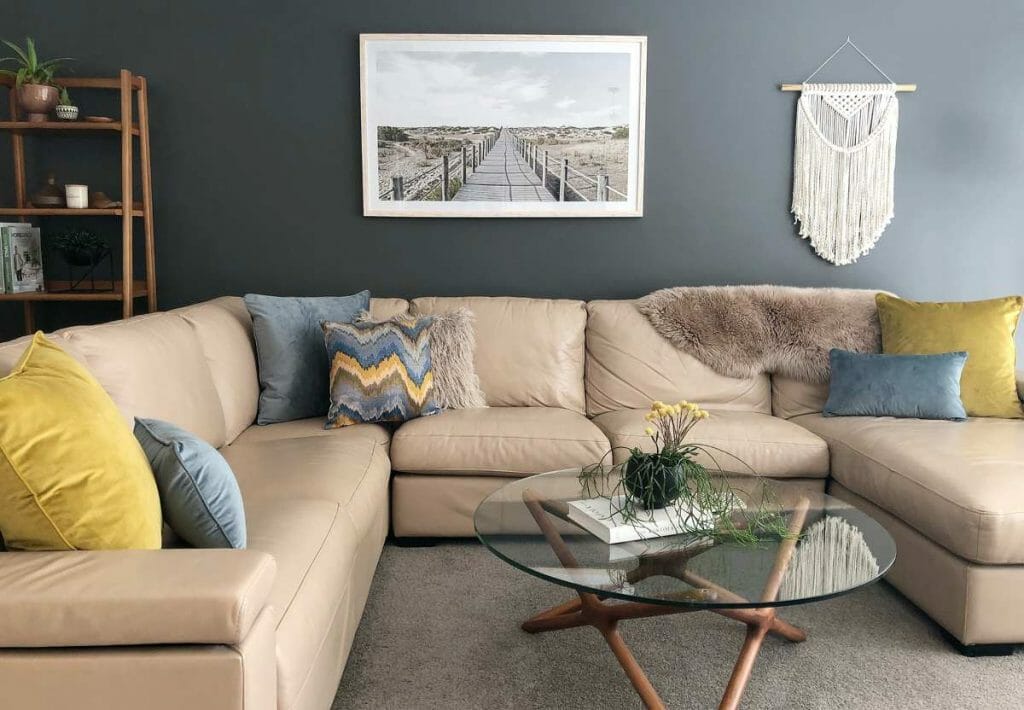 A corner sofa with velvet and furry cushions in mustard and light blue.