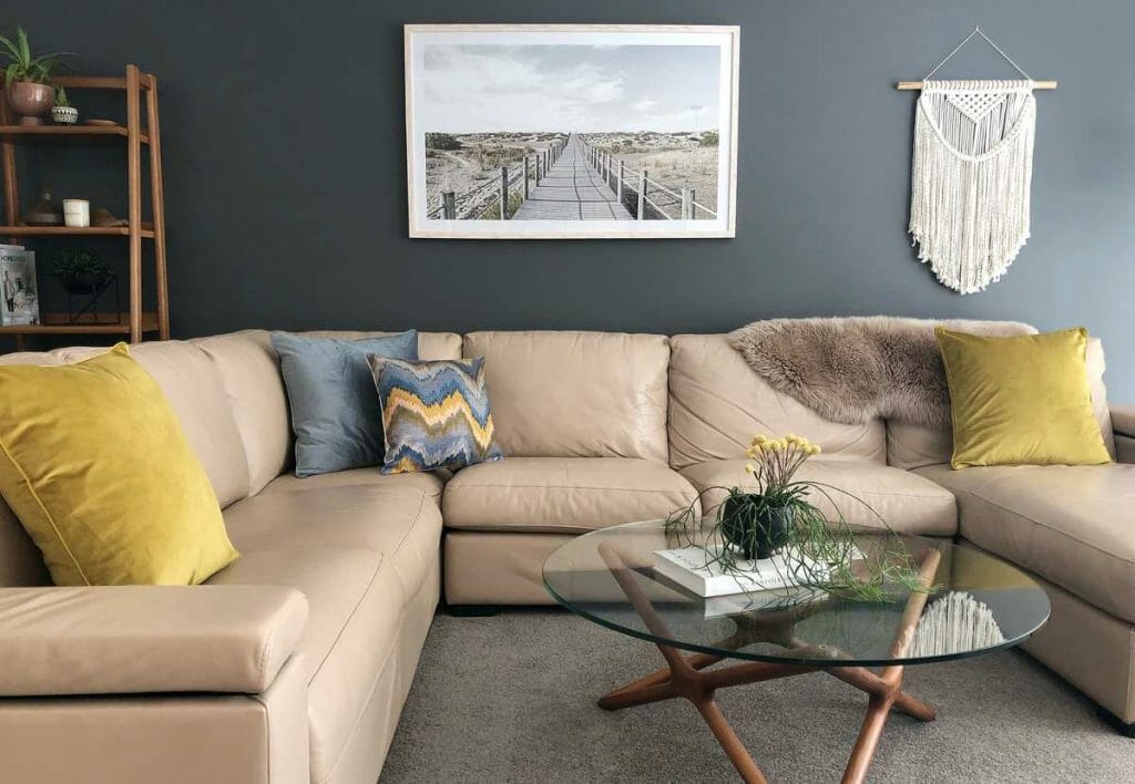 Warm and cozy beige sofa, decorated with soft velvet cushion in mustard and soft blue and a touch of patterned cushion that brings the whole room together.