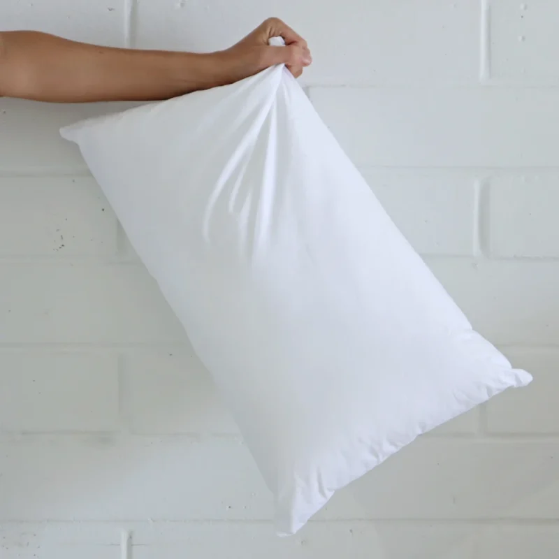 A 30x50 cushion insert inner being held up by an arm.
