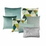 A photo a a set of seven cushion covers in green and grey colours and patterns with a scandi design feel.