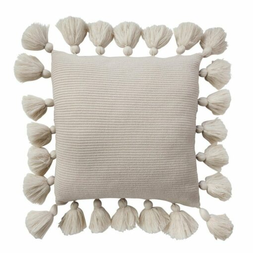 Close up photo of light brown knit cushion with tassels