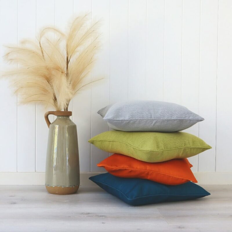Bright-coloured linen cushions against a white wall