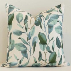 A brick wall that has a floral white cushion cover positioned in front of it. It has an exquisite outdoor material and a lovely square shape.