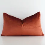 Stylish rust solid-coloured cushion cover constructed from velvet fabric and shown in a rectangle shape.