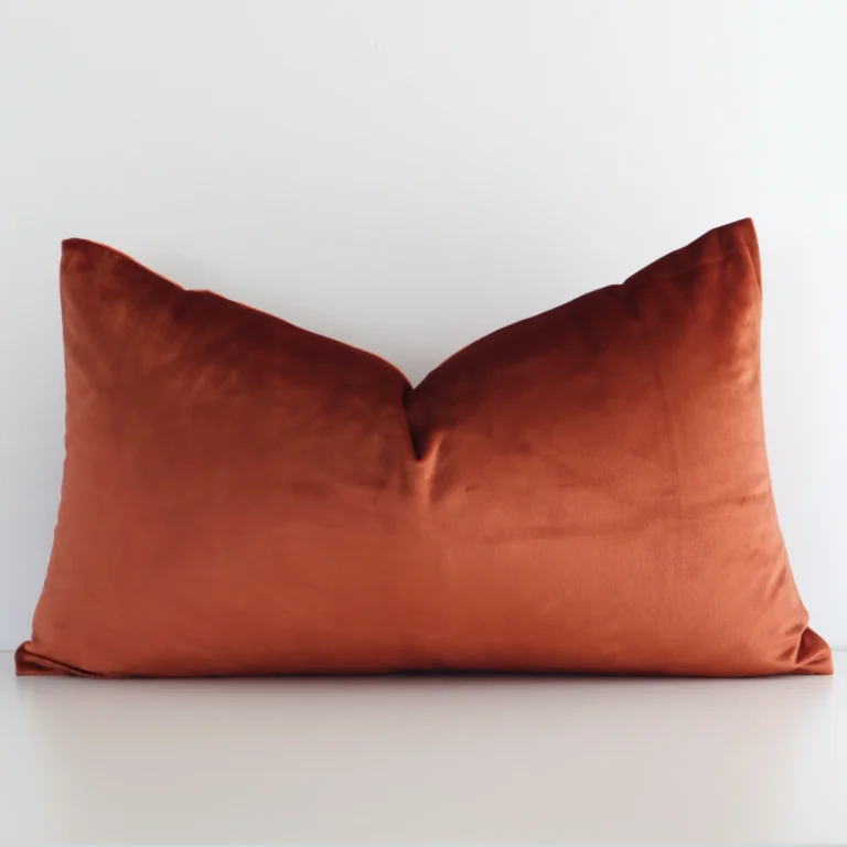 Stylish rust solid-coloured cushion cover constructed from velvet fabric and shown in a rectangle shape.