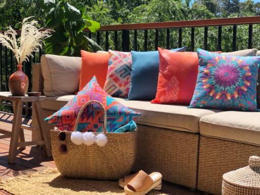 Bright waterproof outdoor cushions in teal and orange sitting on an outdoor lounge