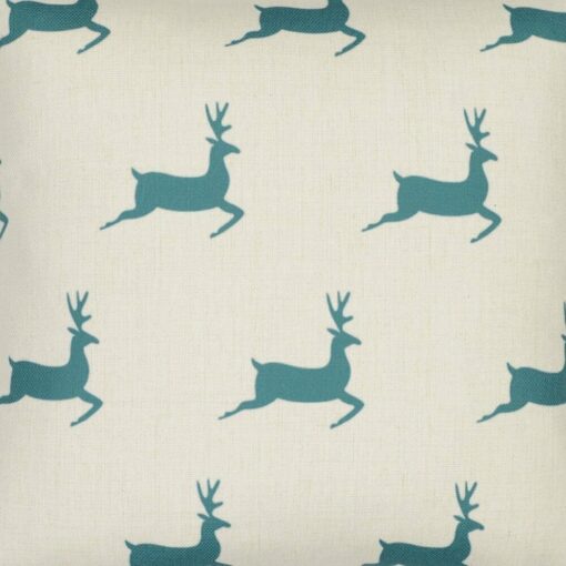 Close up photo of minimalist Christmas inspired cushion with teal reindeers