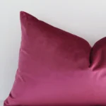 A zoomed view of this velvet blush cushion’s corner that shows a magnified view of its solid colour design and its rectangle shape.