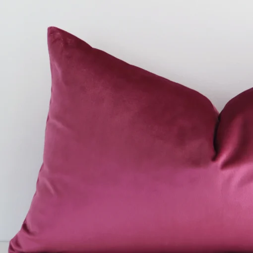 A zoomed view of this velvet blush cushion’s corner that shows a magnified view of its solid colour design and its rectangle shape.