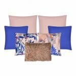 An collection of seven cushion covers in pink and blue colours and floral designs.