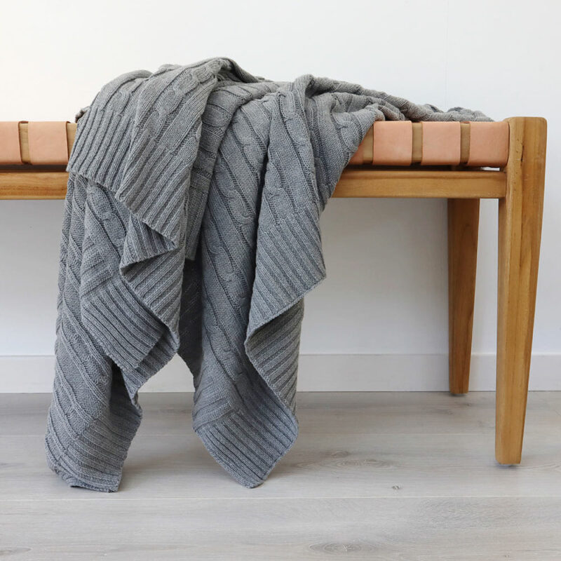 Grey Knitted Throw - 130x150cm - TH118 An image of a grey knitted throw draped over a stool