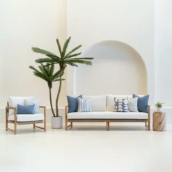 Living room scene with 7 horizon blue outdoor sofa cushions arranged on a white sofa.