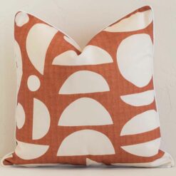 An eye-catching outdoor square cushion cover featuring a hue that is rust. It has a unique geometric style.
