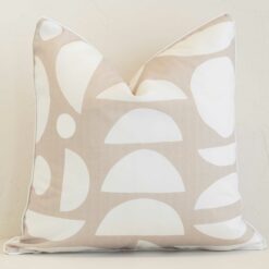 Sand geometric cushion cover sits against a white wall. It is constructed from a superior looking outdoor material and has square dimensions.