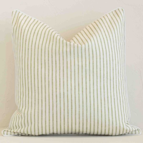 Outdoor square cushion with a stripe design in an upright position against a white brick wall. It is sage in colour.