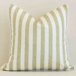 Sage outdoor cushion cover features prominently against a white wall. It is a square design and has a stripe decorative finish.