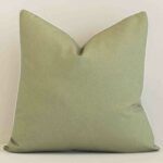 A hero shot of a solid-colour large cushion cover. It is made from a deluxe outdoor fabric and features a sage colour.
