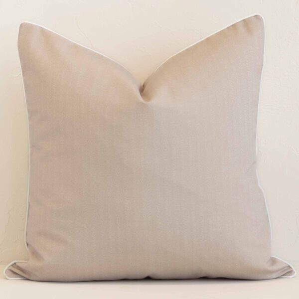 A lovely large sand cushion cover arranged in front of a white wall. The solid-colour style complements the outdoor material.