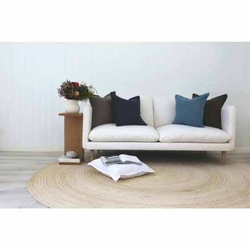 Grey and blue cushions sitting on 2 seater white sofa.