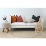 Autumn-coloured linen cushions on two-seater white sofa