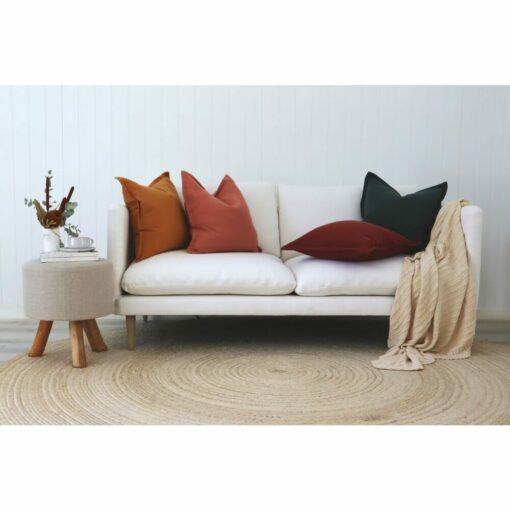 Various coloured linen cushions and cream throw on a white sofa