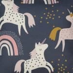 Close up image of dark coloured kids cushion with pink unicorns and rainbows