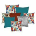A collection of eight colourful cushion covers in red, green and grey colours with four scandi design printed cushion covers, two blue cushion covers, one red cover and one grey fluffy cushion cover.