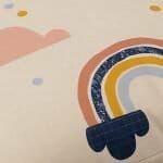 Close up image of pretty kids floor cushion with colourful rainbows and clouds