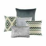 A photo of a set of 5 grey cushion covers featuring a two grey cushions with patterns, one charcoal grey cushion cover, one grey cushion cover and a single rectangular grey faux fur cushion cover.