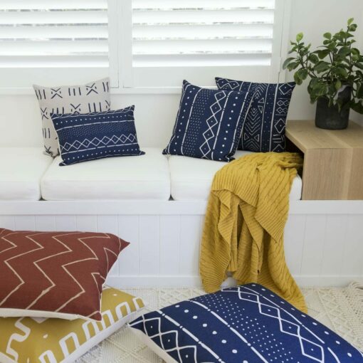 Colourful cushions with tribal prints perfectly paired with mustard knit throw blanket