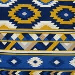 Close up image of Mexican tribal inspired cushion cover with white, blue and yellow colours