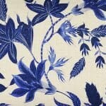 Close up image of white rectangular cushion cover with blue lily flowers