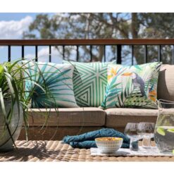 Green, tropical themed green outdoor cushions on brown sofa