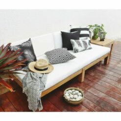 Black and white outdoor cushions placed on wooden daybed
