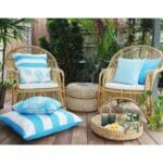 Blue outdoor cushions in stripe, diamond and floral patterns on top of rattan lounge chairs.