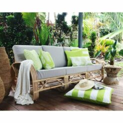 Bright green and white outdoor cushions in stripe, block, diamond and floral patterns on top 3-seater rattan sofa.