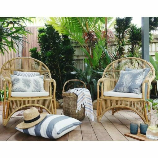 Grey outdoor cushions in mixture of patterns on top of rattan lounge chairs.