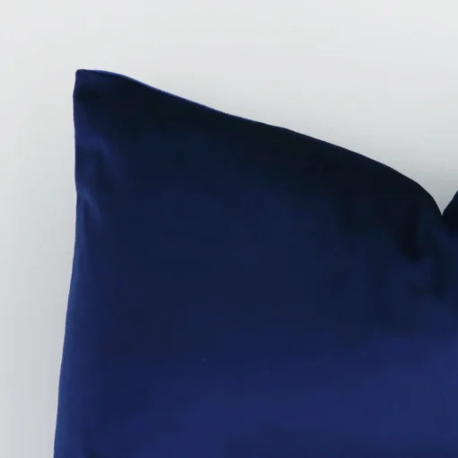 A detailed shot of this royal blue solid-coloured cushion cover that has velvet fabric and a rectangular shape.