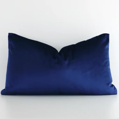 Royal Blue Velvet Cushion Cover – Rectangle SC789-30c Royal blue velvet cushion cover features prominently against a white wall. It is a rectangular design and has a solid colour finish.